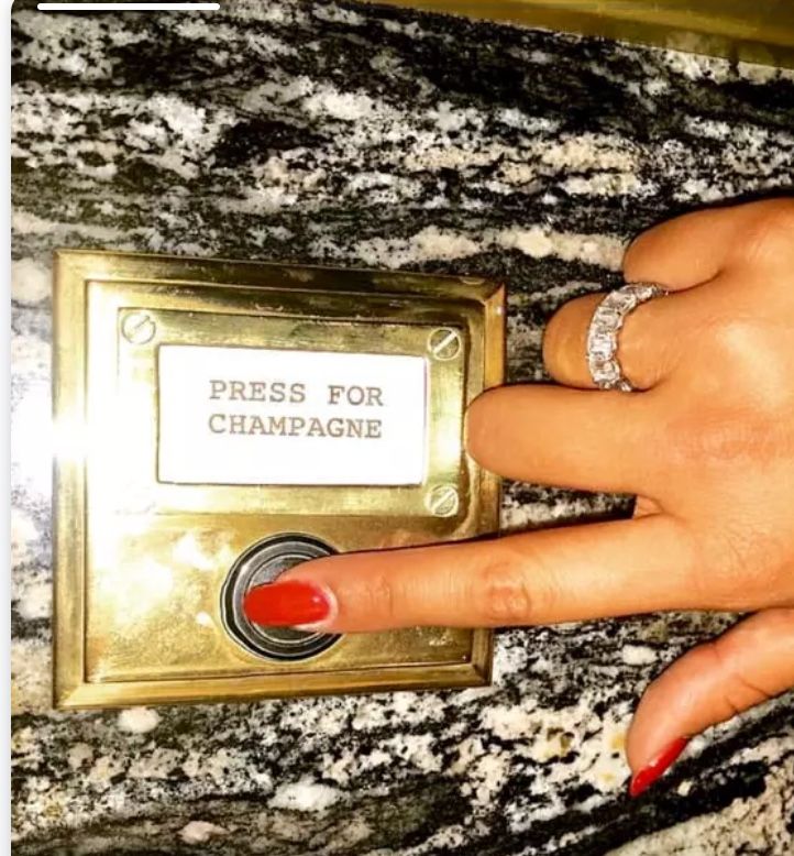 A brass doorbell plate that reads Press for champagne